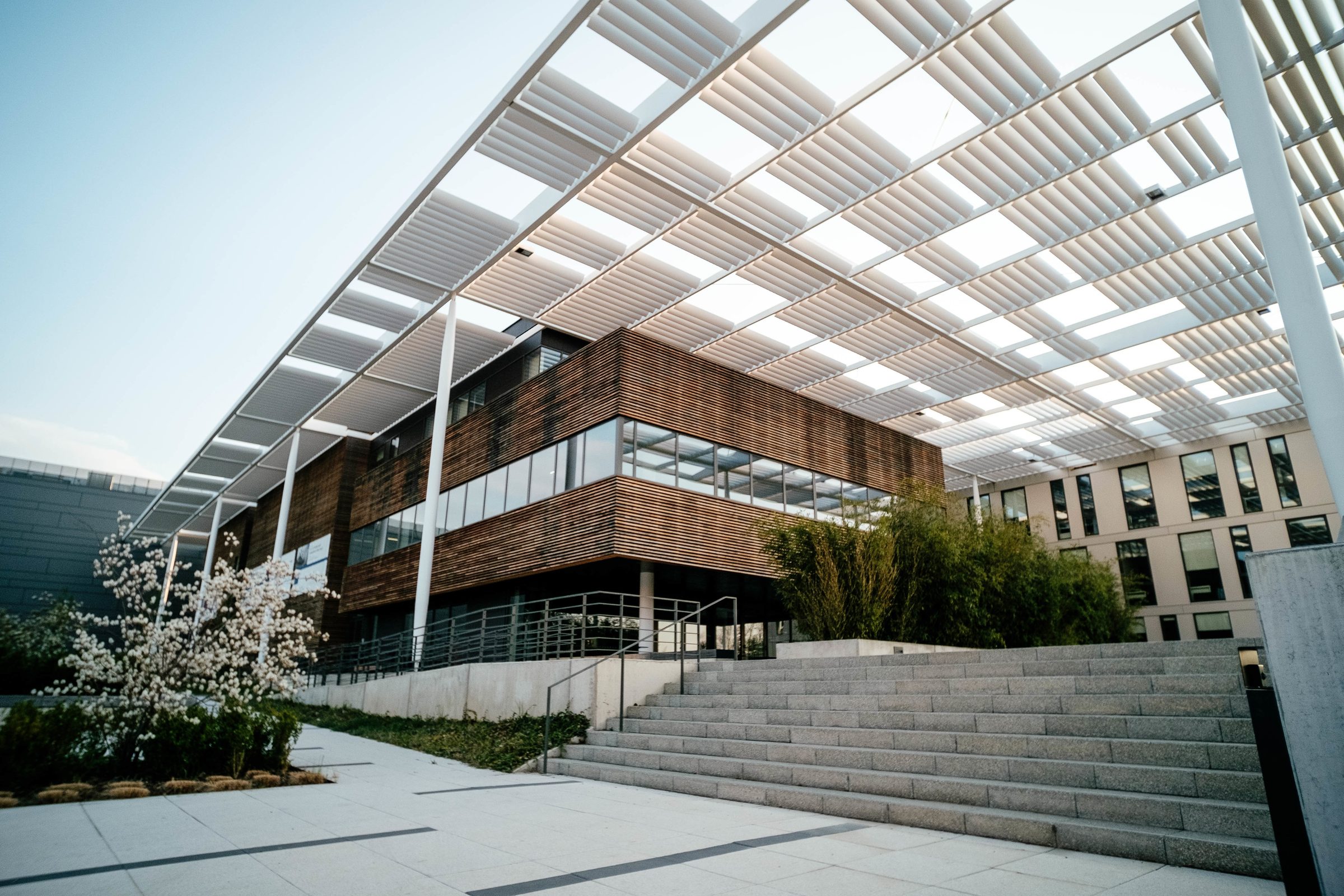 Edifício contemporâneo com pergolado e fachada em madeira